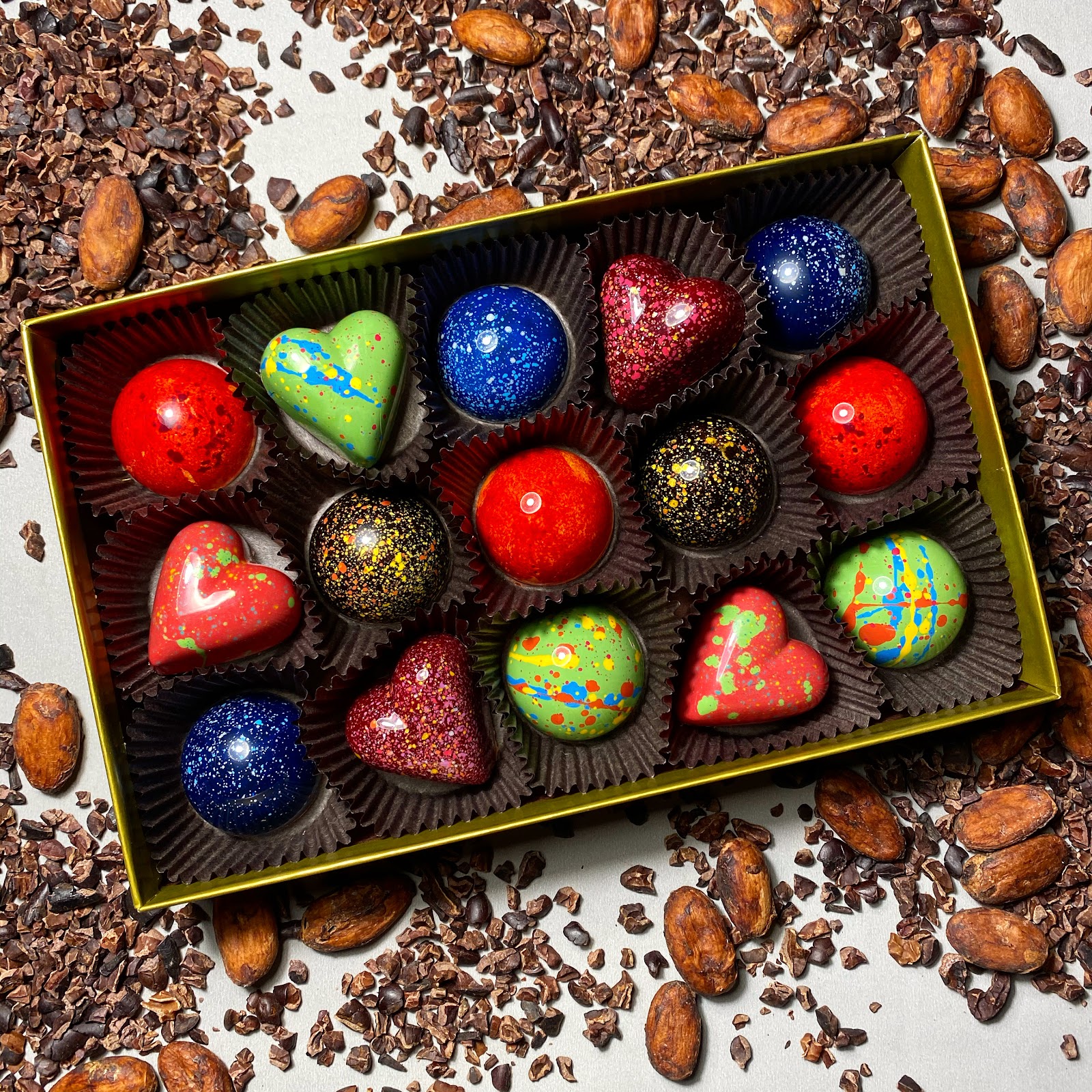 Caja artesanal rodeada de cacao y bonbones pintados