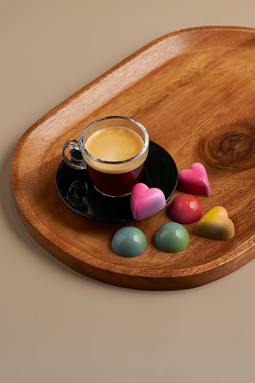 Cafe espresso con bombones sobre bandeja de madera